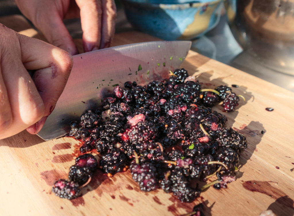 Maulbeeren werden mit Messer gehackt.